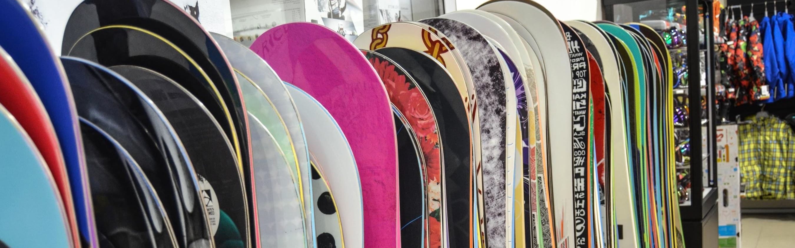 Snowboards in a line at a snowboard shop. 