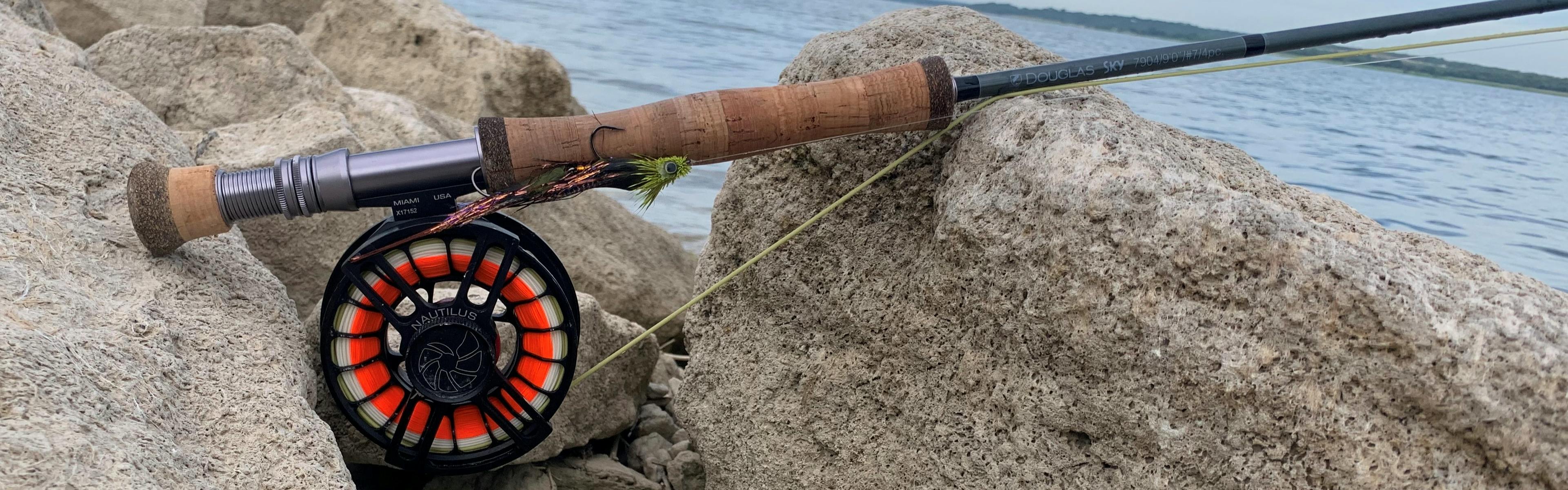 The author's fly rod set-up rests on a rock by the water with a streamer attached to the line.
