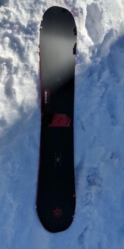 A new Typo snowboard sitting on the snow.