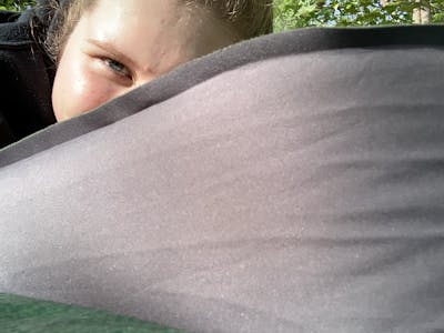 Photo taken looking up at a woman who is sleeping on an ExPed MegaMat Sleeping Pad.