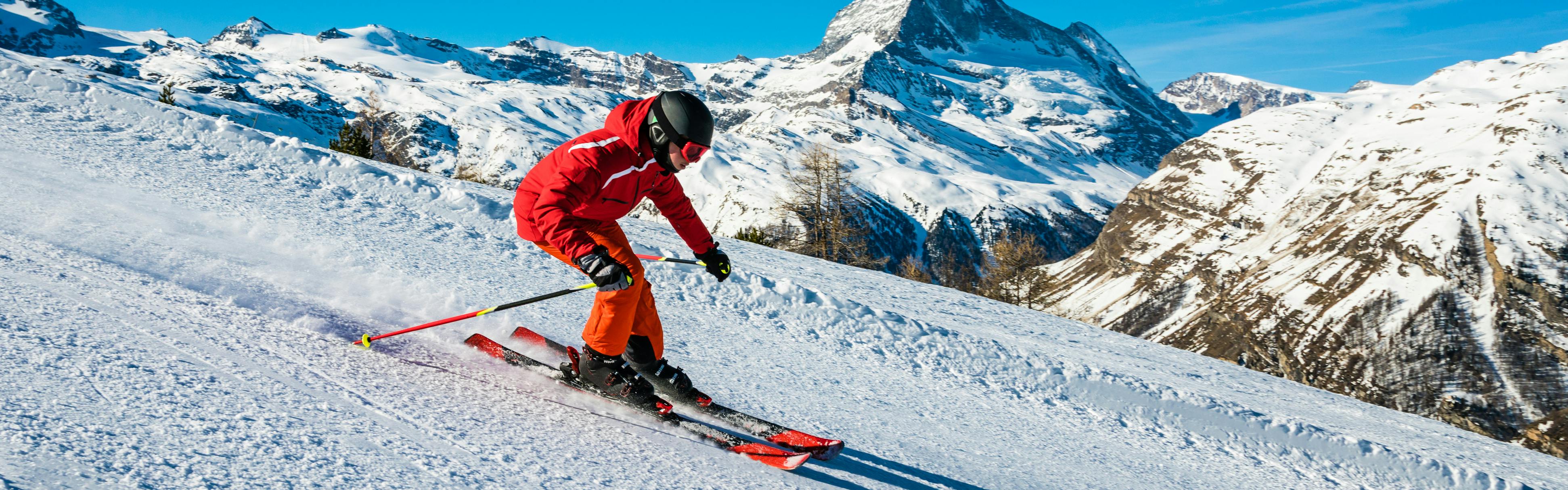 Skier skiing down a groomed slope