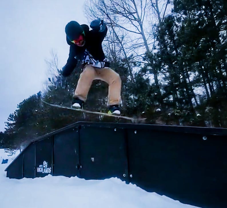 A snowboarder hitting a rail. 