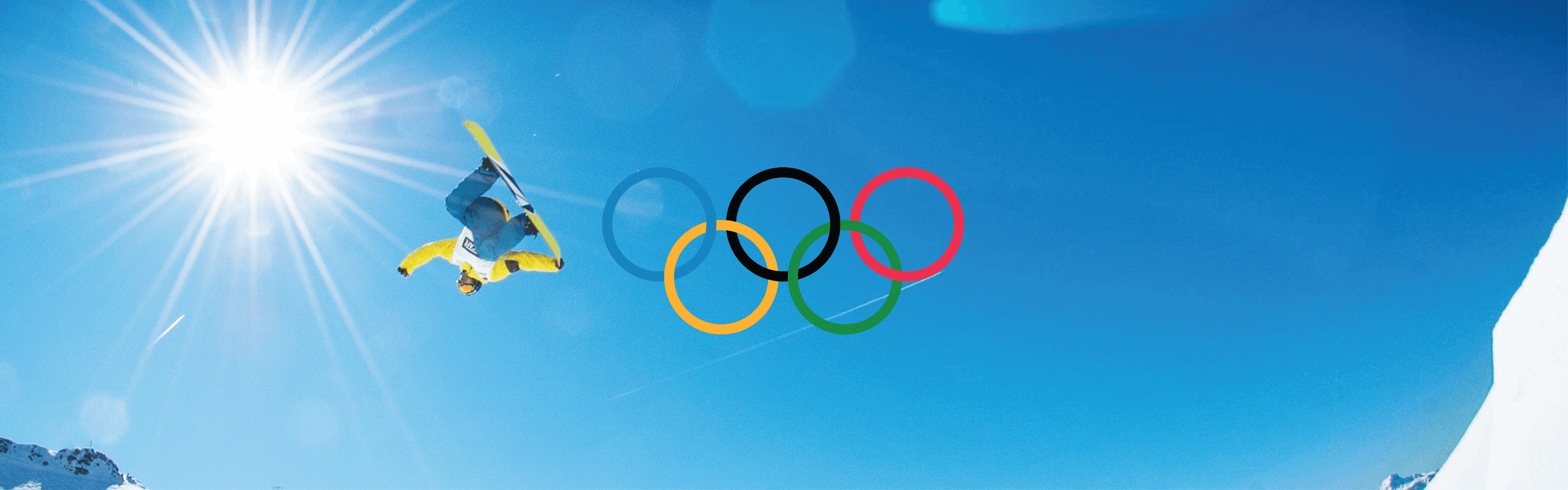 A snowboarder jumps upside down and grabs his board on a blue-sky, sunny day. The Olympic rings are added on top. 