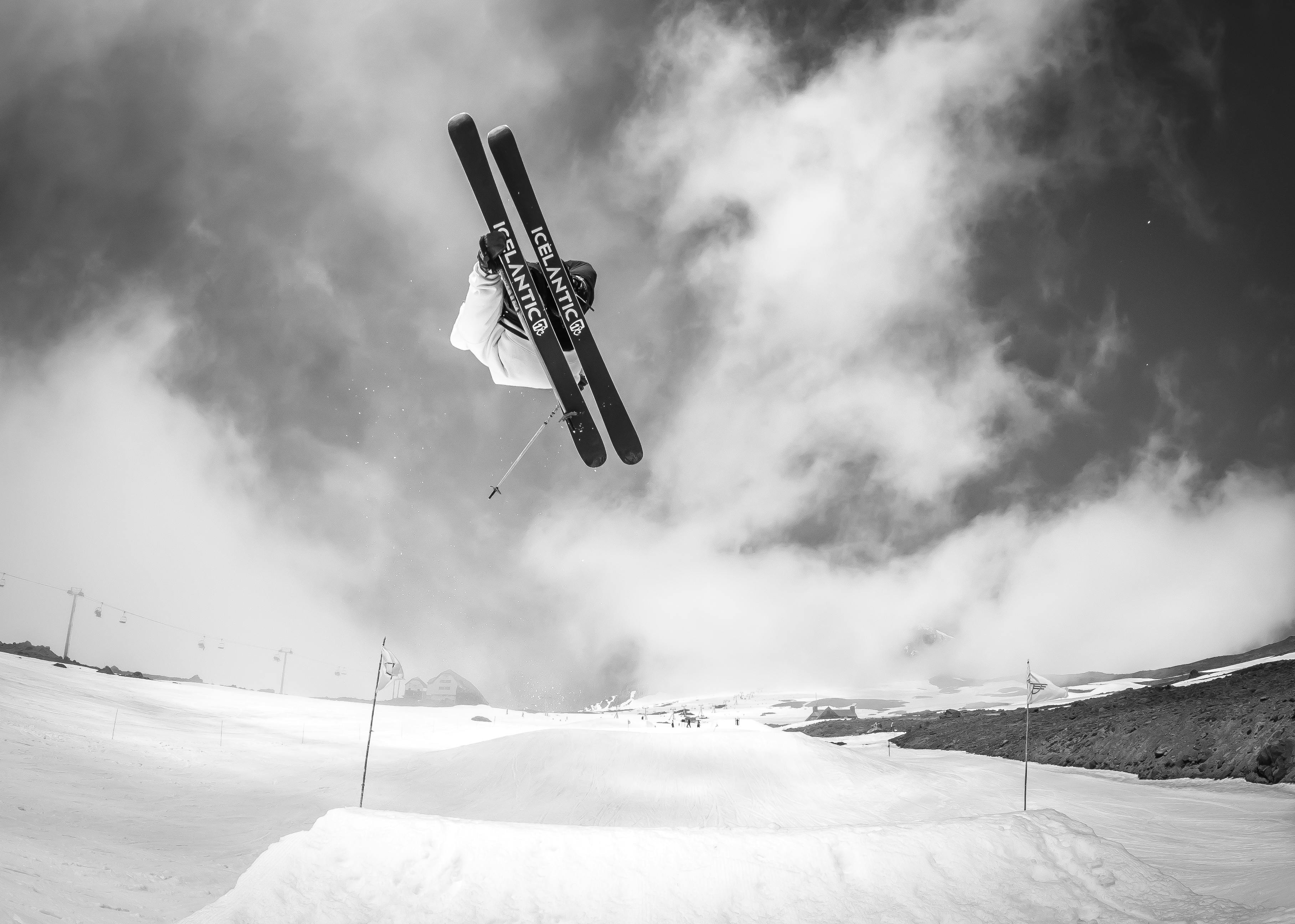 A skier executing a jump in the terrain park with Icelantic skis