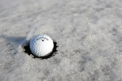A Callaway 2021 REVA Golf Ball sitting in the snow. 