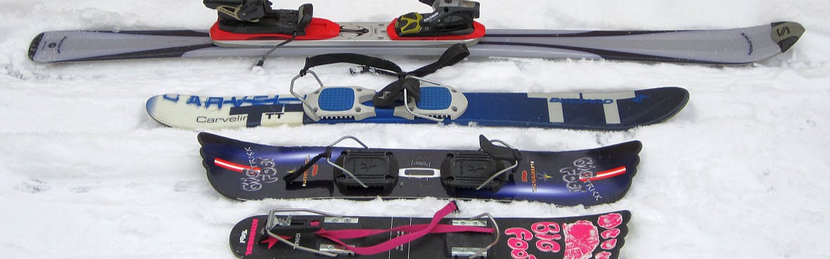 Four varying sizes of skis from regular skis at the top to a few types of ski blades below.