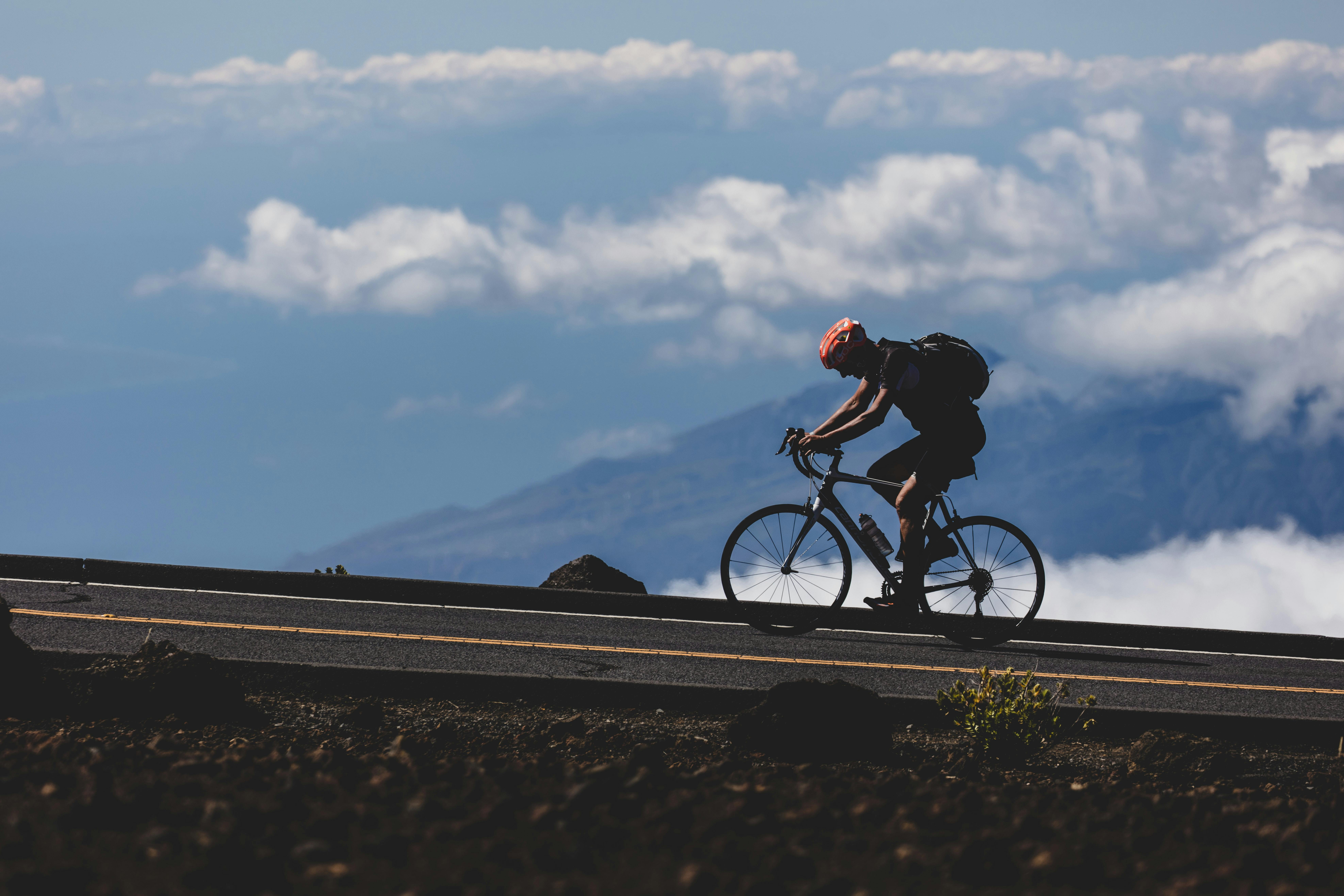 A biker riding uphill on the road at high elevation
