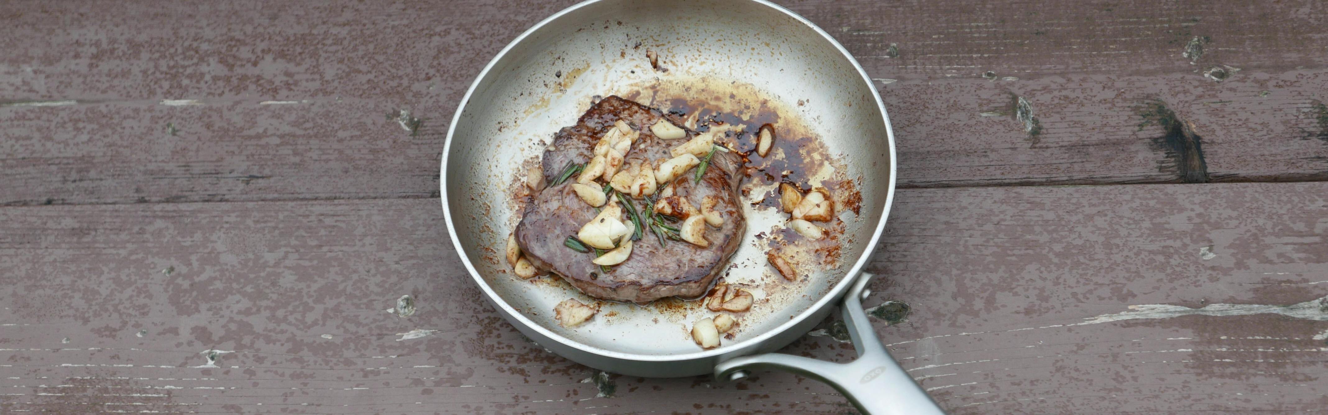 A pan-seared steak sits in the author's frying pan.