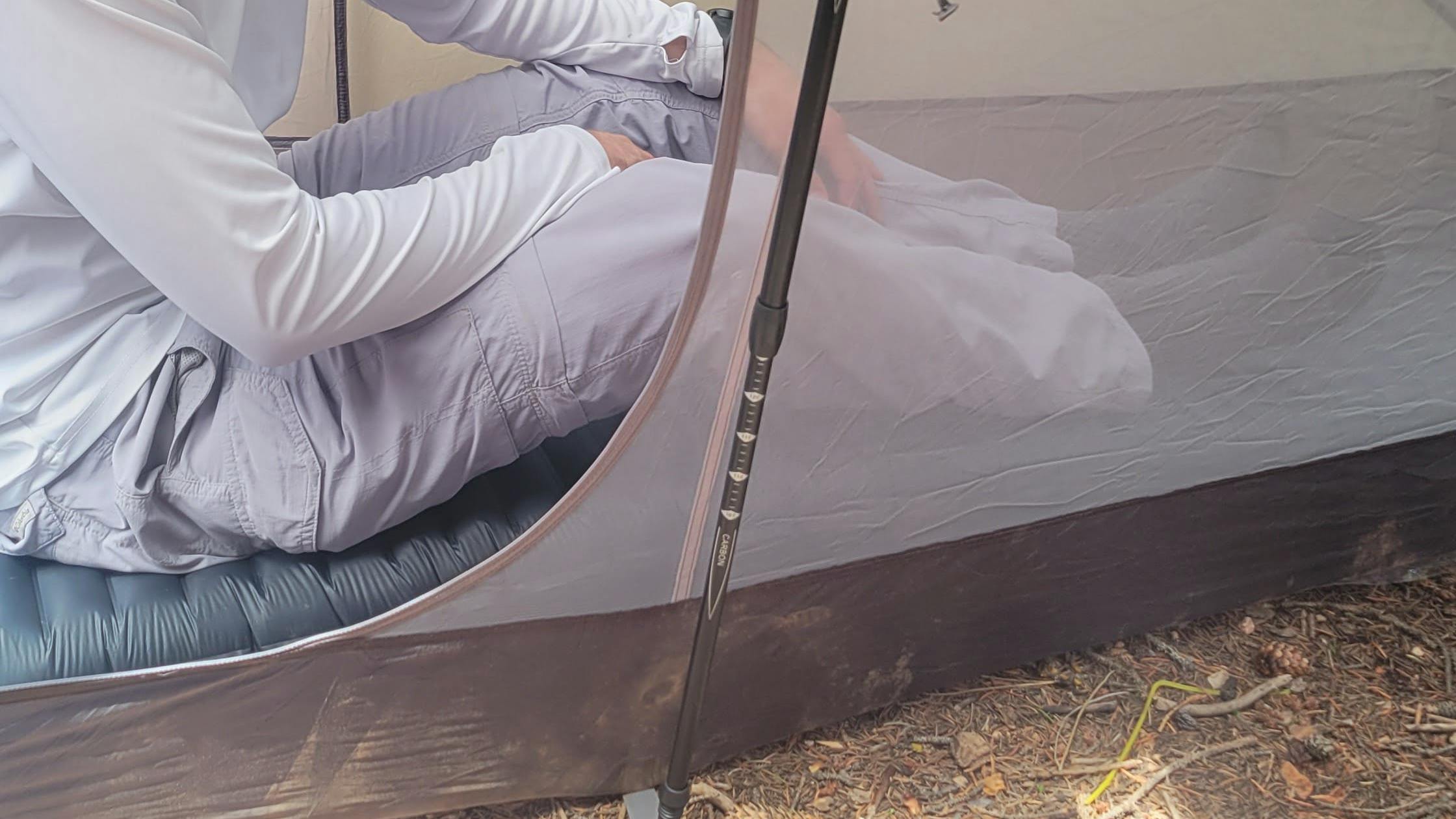 A camper sitting in his tent on the Therm-A-Rest NeoAir UberLight Sleeping Pad.