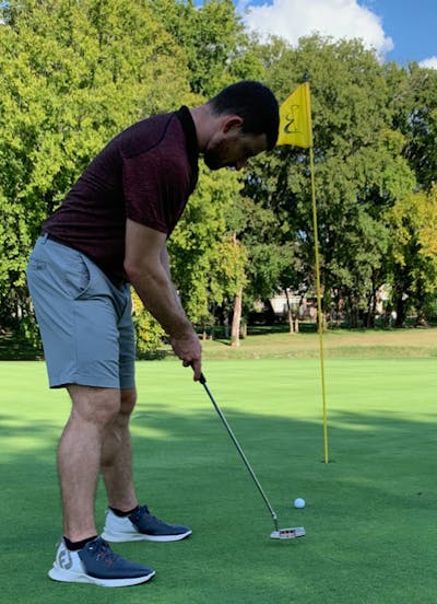 A man putting with the Wilson 2022 Tour Velocity Distance Golf Ball.