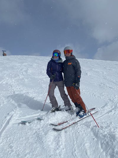 Two people at the base of a ski run. 