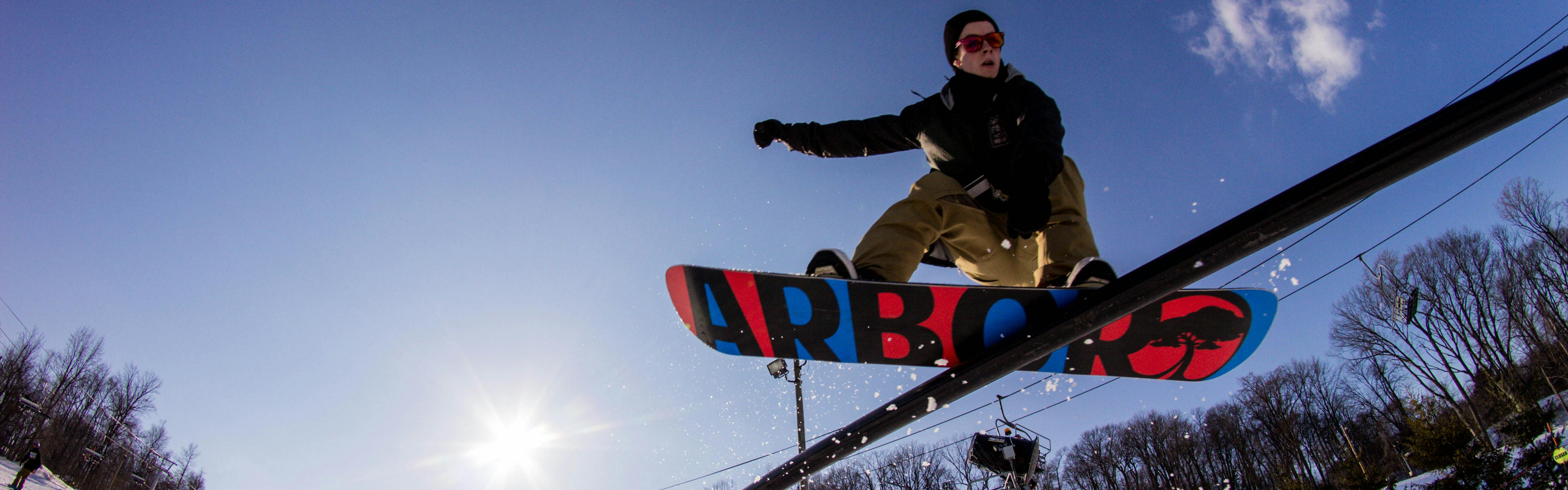 A snowboarder slides down a rail