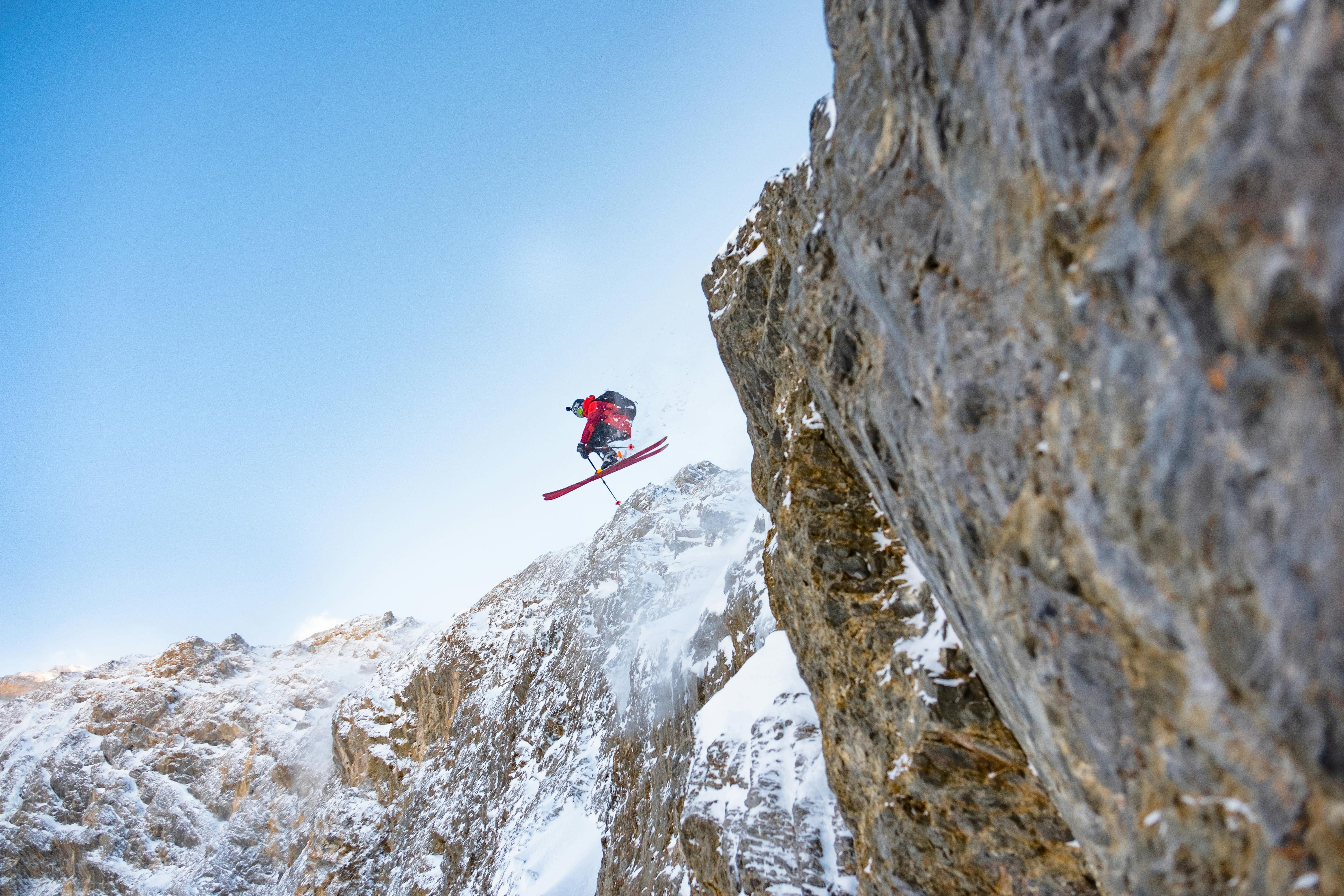 A skier jumping off a rocky cliff