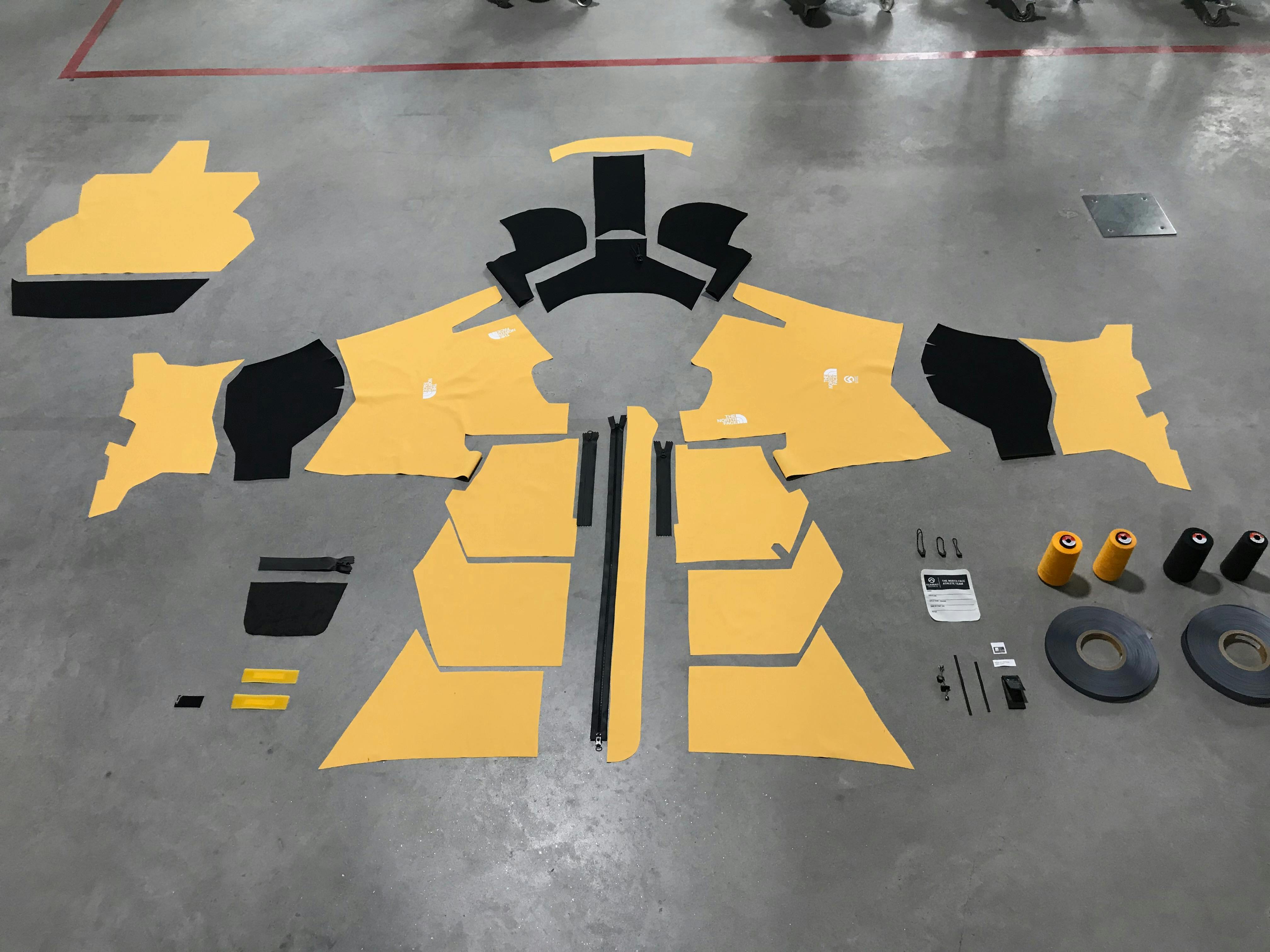All the individual components of a North Face jacket laid out on the factory floor.