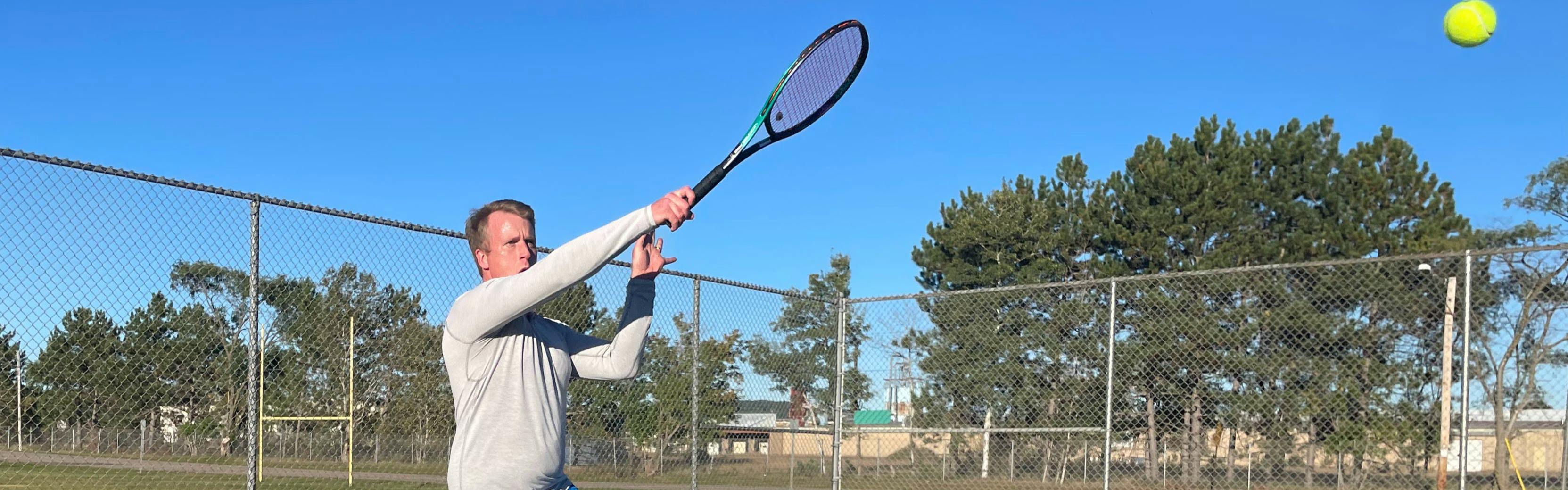 A tennis player hitting a ball with the  Yonex VCore Pro 97D Racquet · Unstrung.