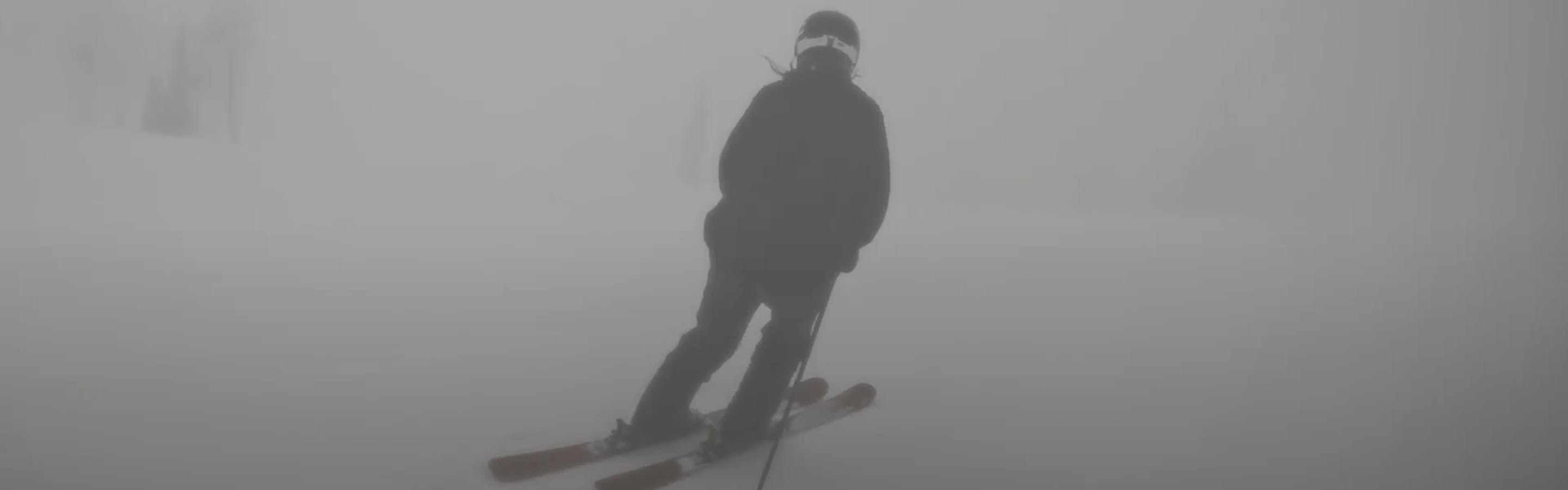 A skier carving down a mountain. 