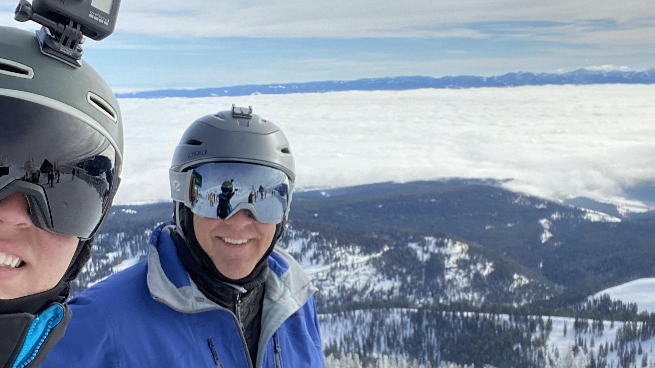 The author takes a selfie with his dad while they wear ski helmets.