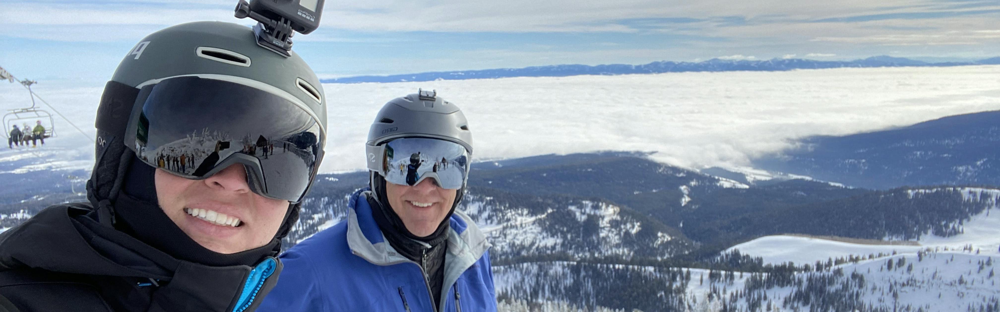 The author takes a selfie with his dad while they wear ski helmets.