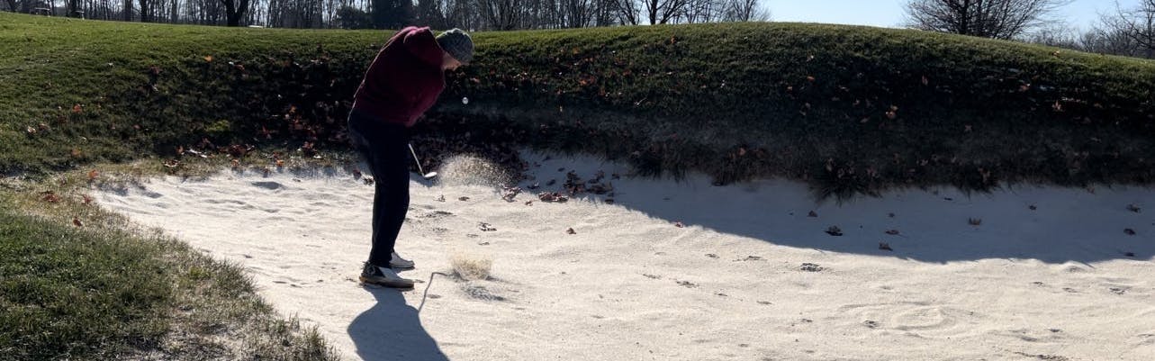 A golfer using the  Titleist TruFeel Golf Balls in a sand pit.