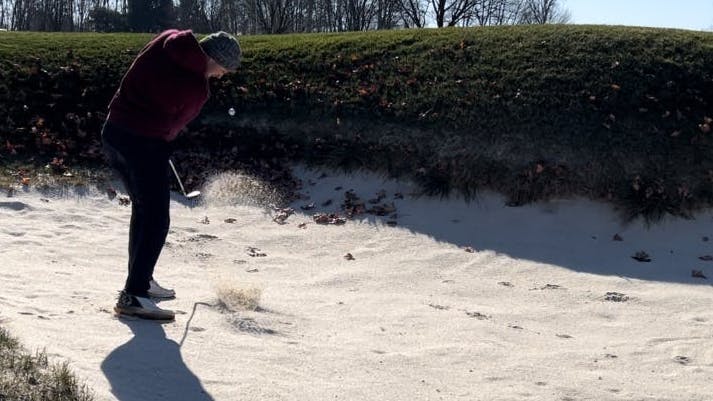 A golfer using the  Titleist TruFeel Golf Balls in a sand pit.