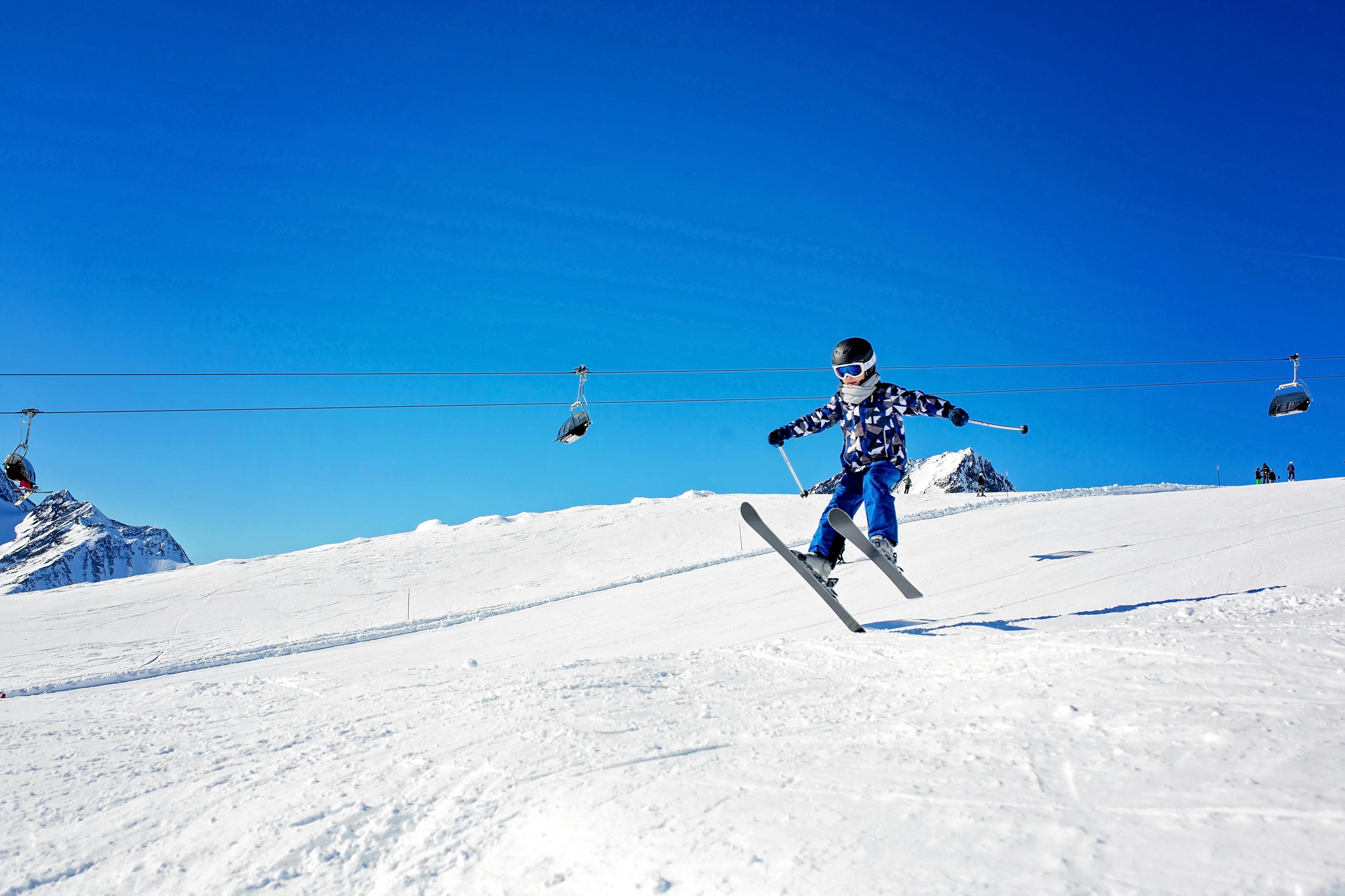 A young girl on skis catches air