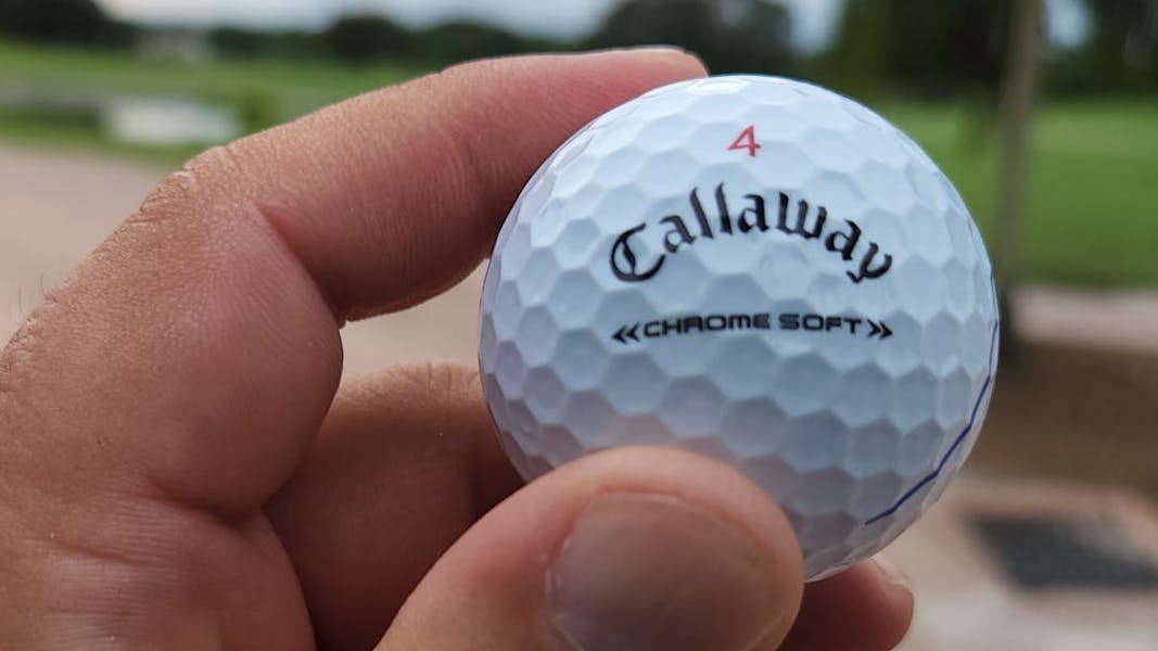 A man holding a Callaway 2022 Chrome Soft Triple Track Golf Ball.