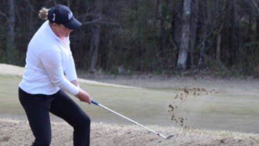 A woman uses the Callaway MD5 JAWS Wedge in a sand trap.