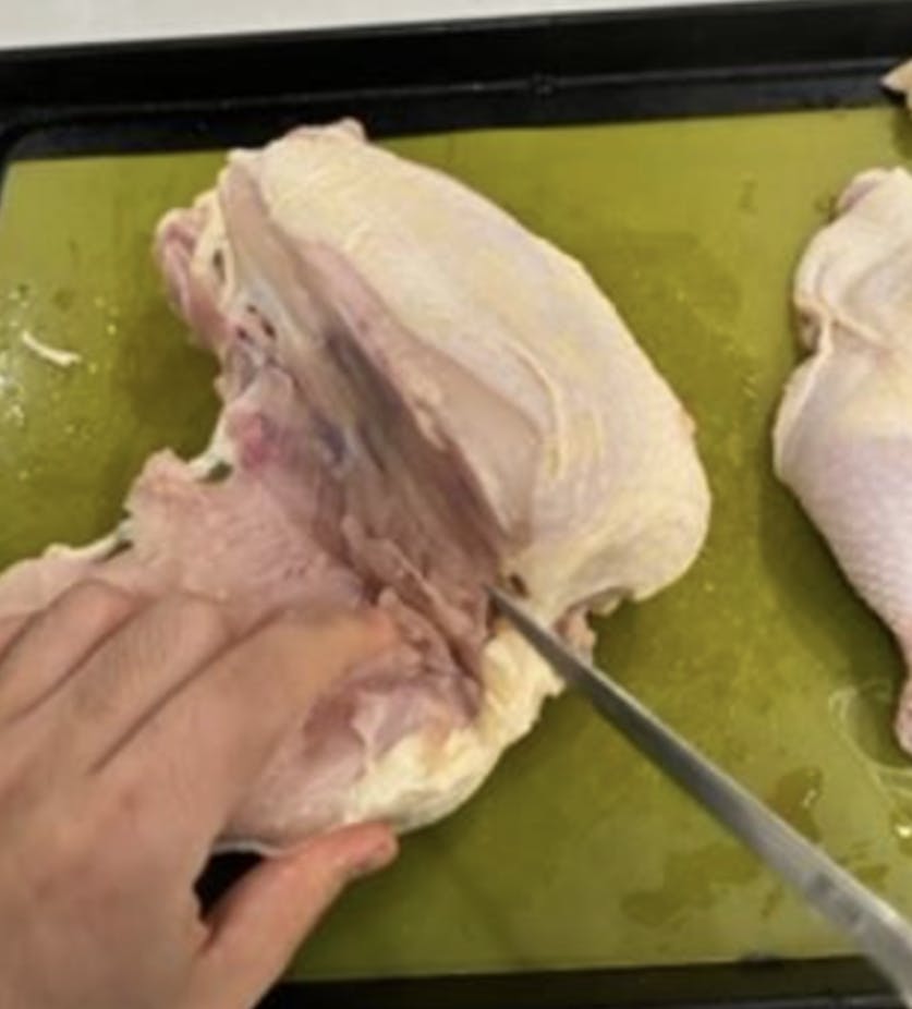 A close up of cutting a chicken breast. 
