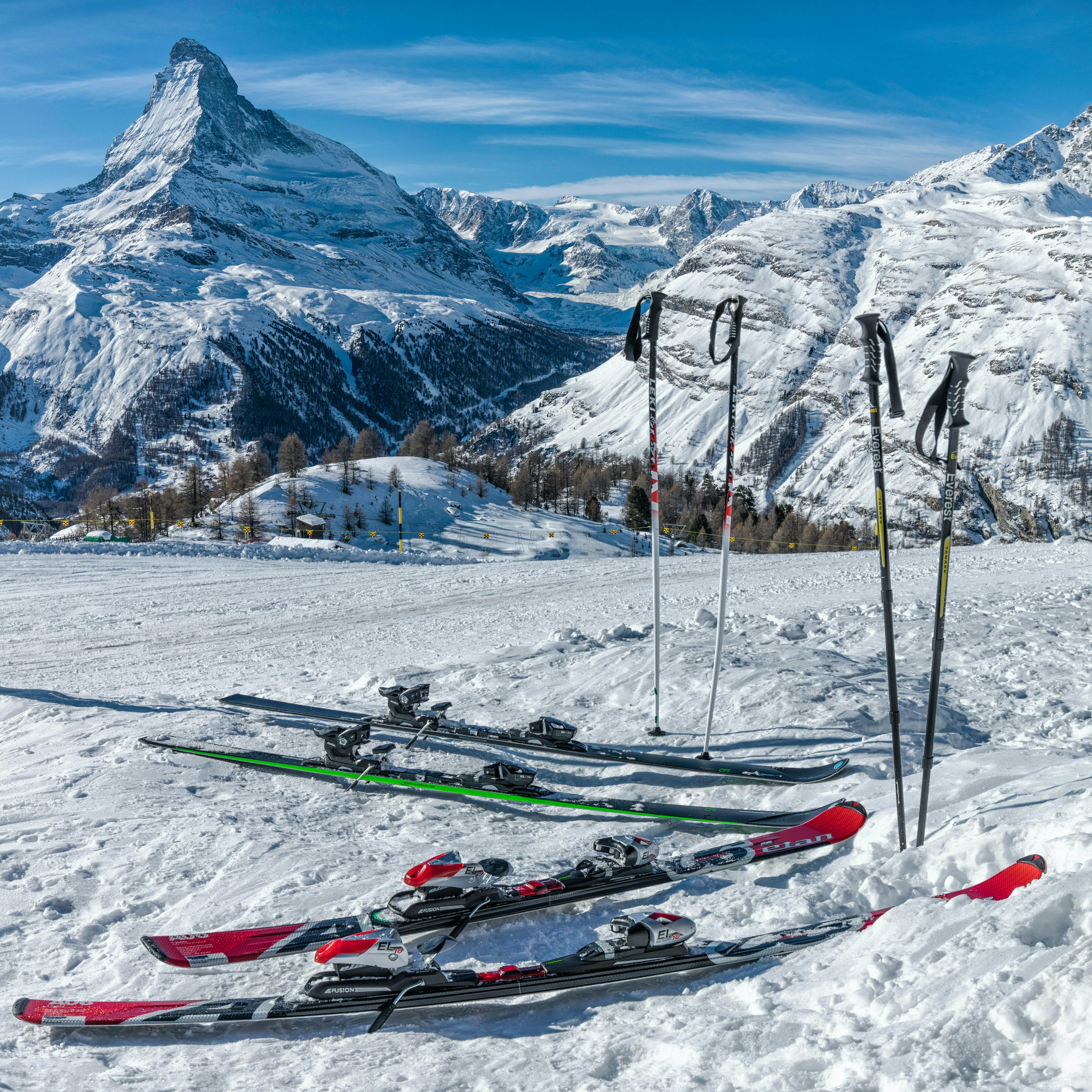 Skis and poles sit on a ski slope with the Matterhorn in the background.