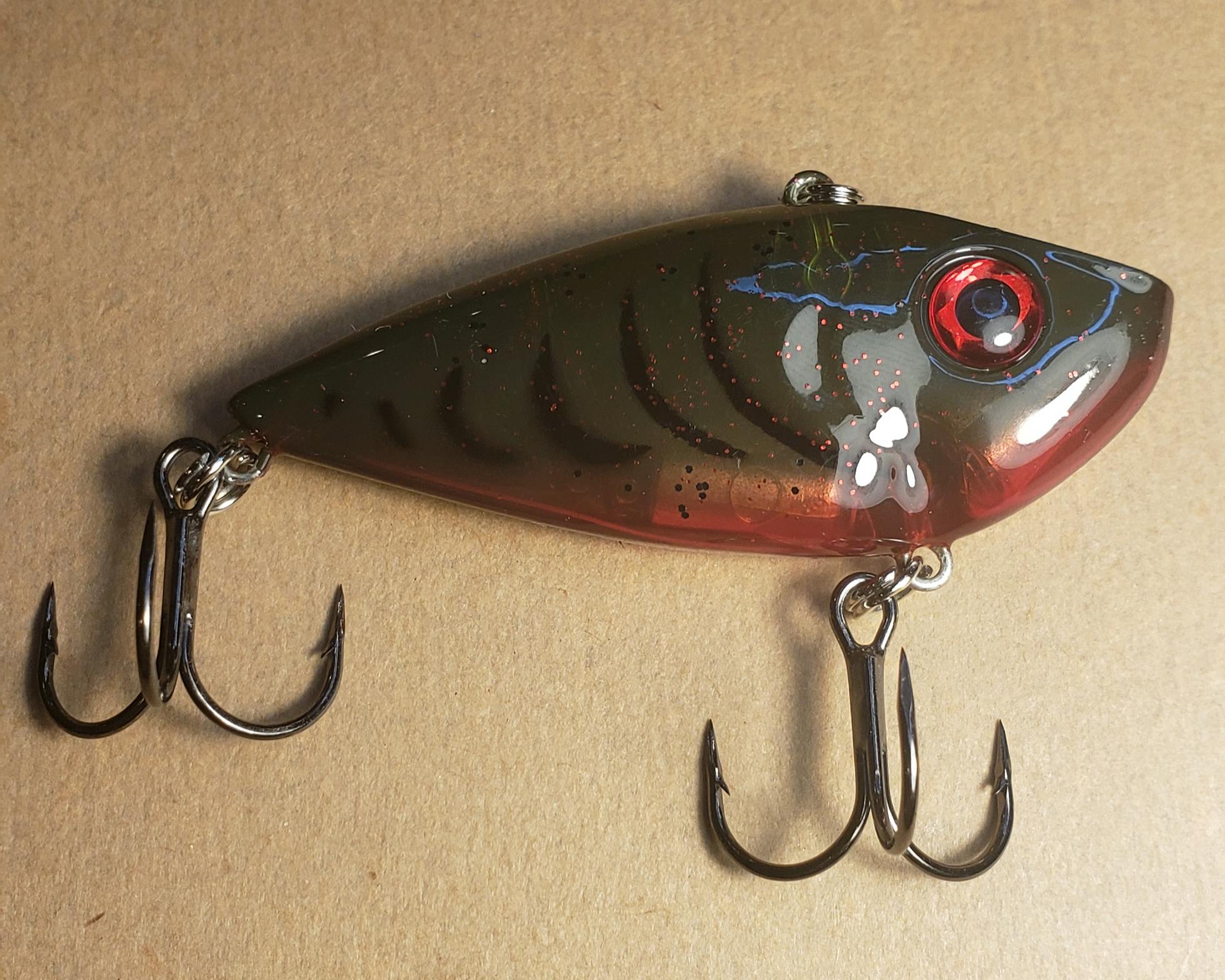 Strike King Red Eye Shad in the Chili Craw Pattern on a plain tan background.