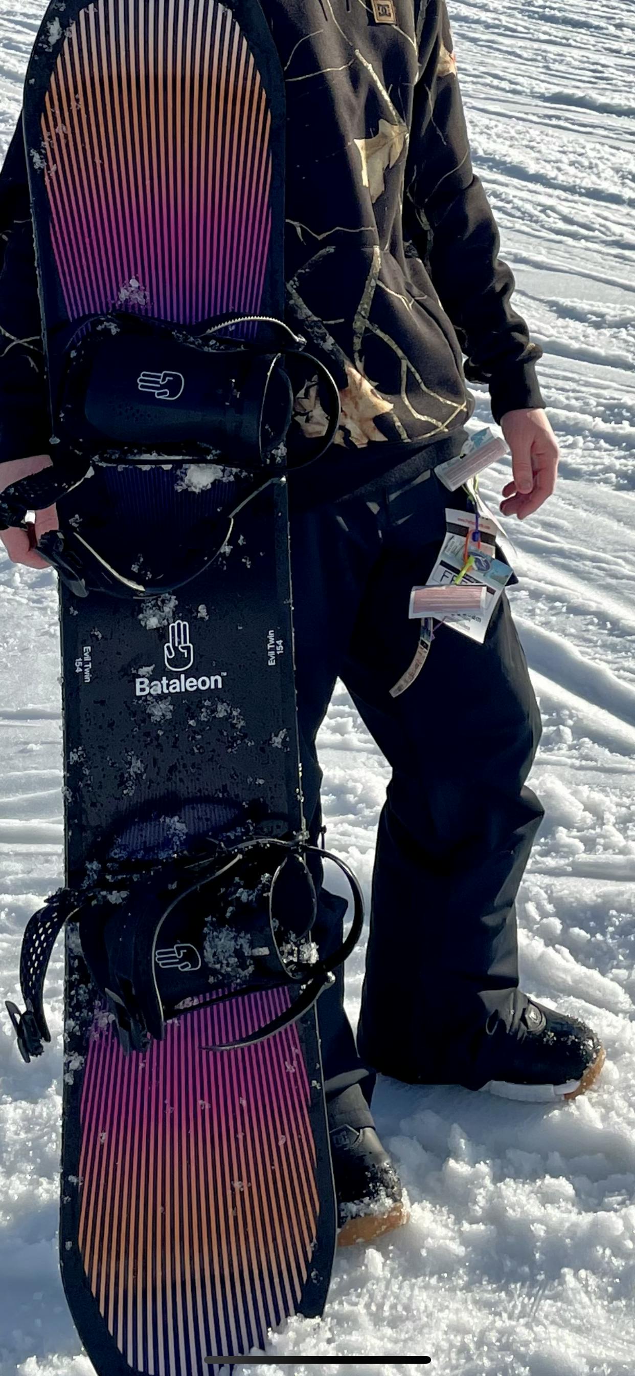 A man holding a snowboard on a snowy trail while wearing the DC Control Snowboard Boots. 