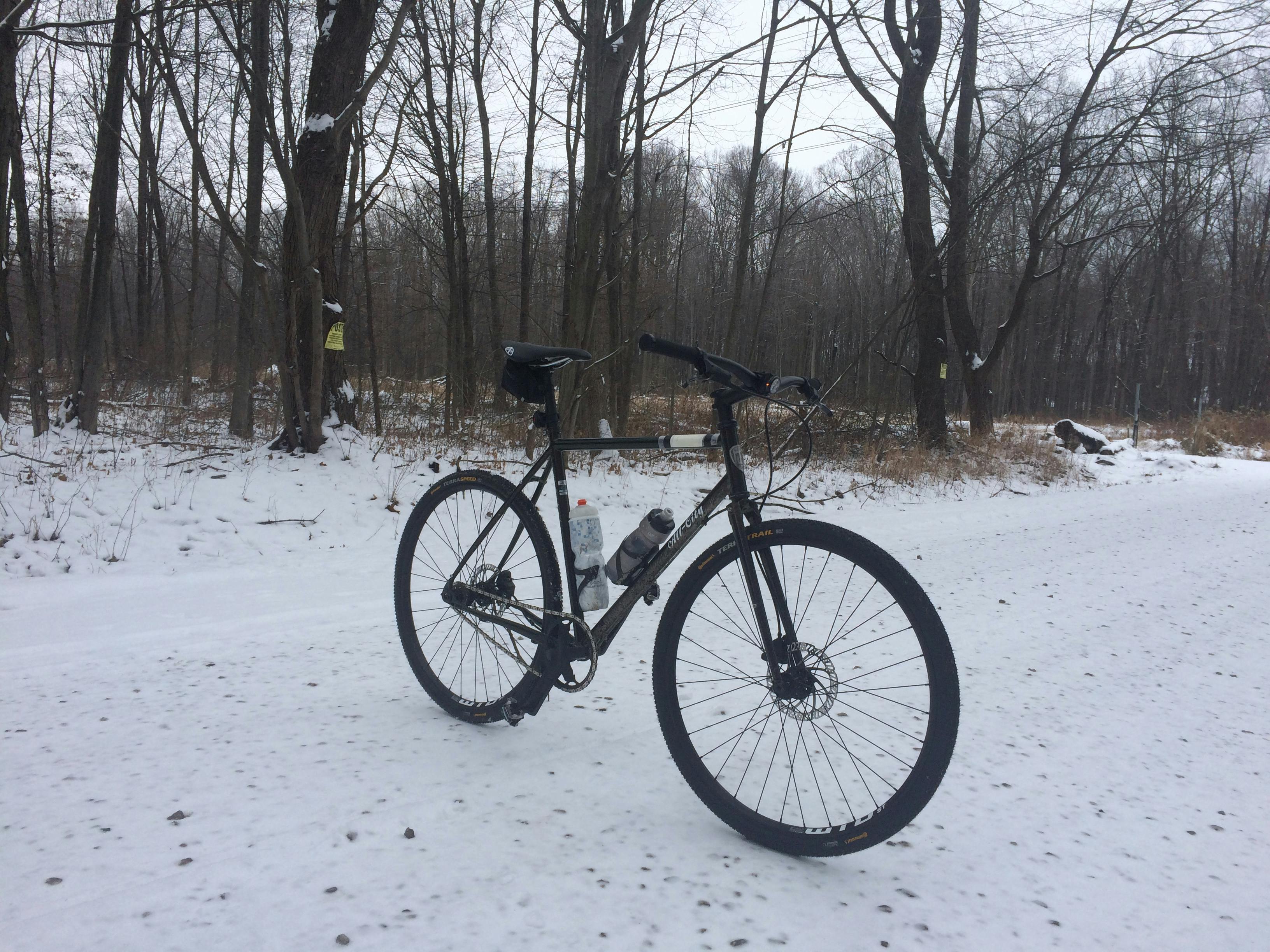 A bike sitting on a snowy trail.