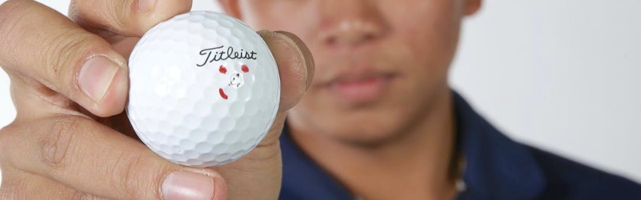 A man holding a Titleist Pro V1 Golf Ball. 