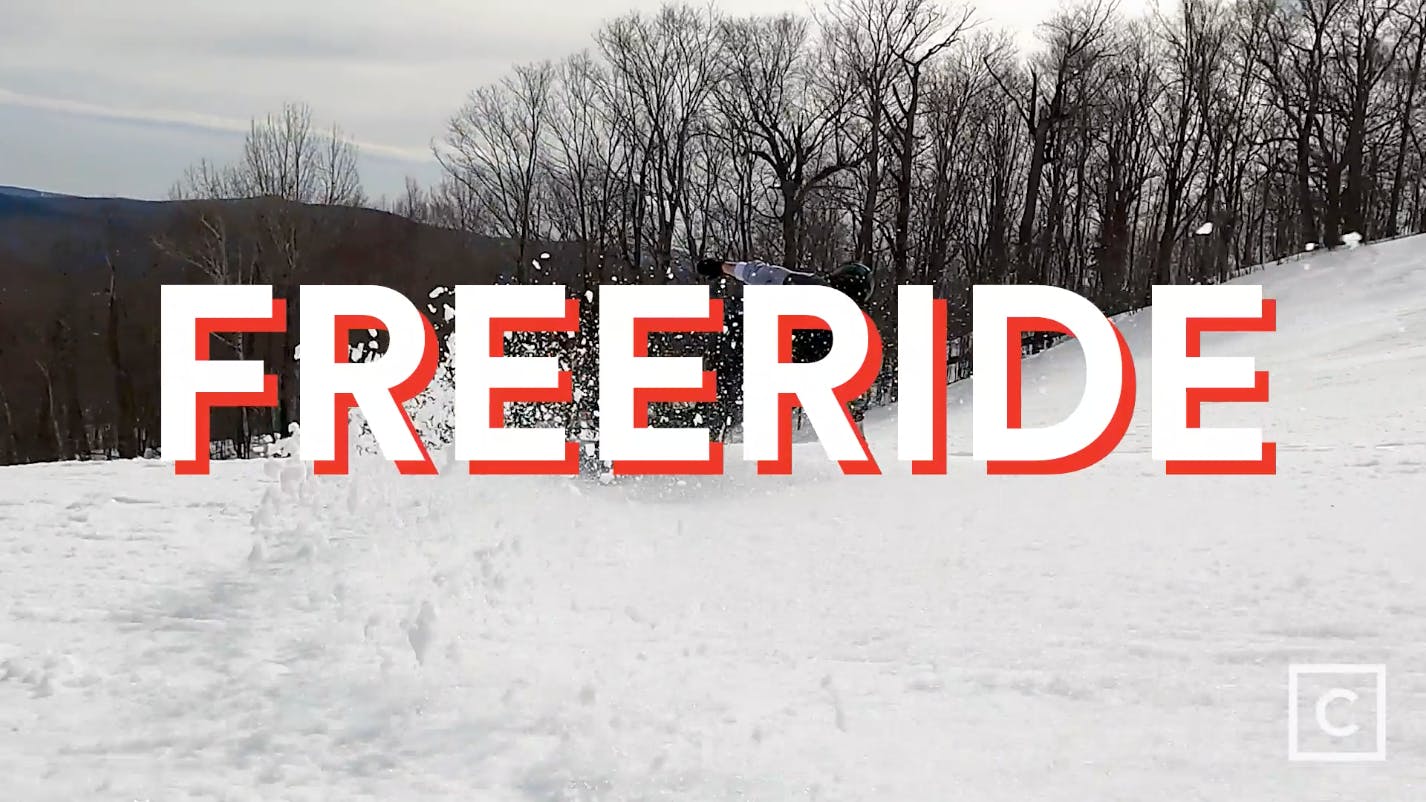 A wave of snow from a snowboarder with a "Freeride" graphic over the image