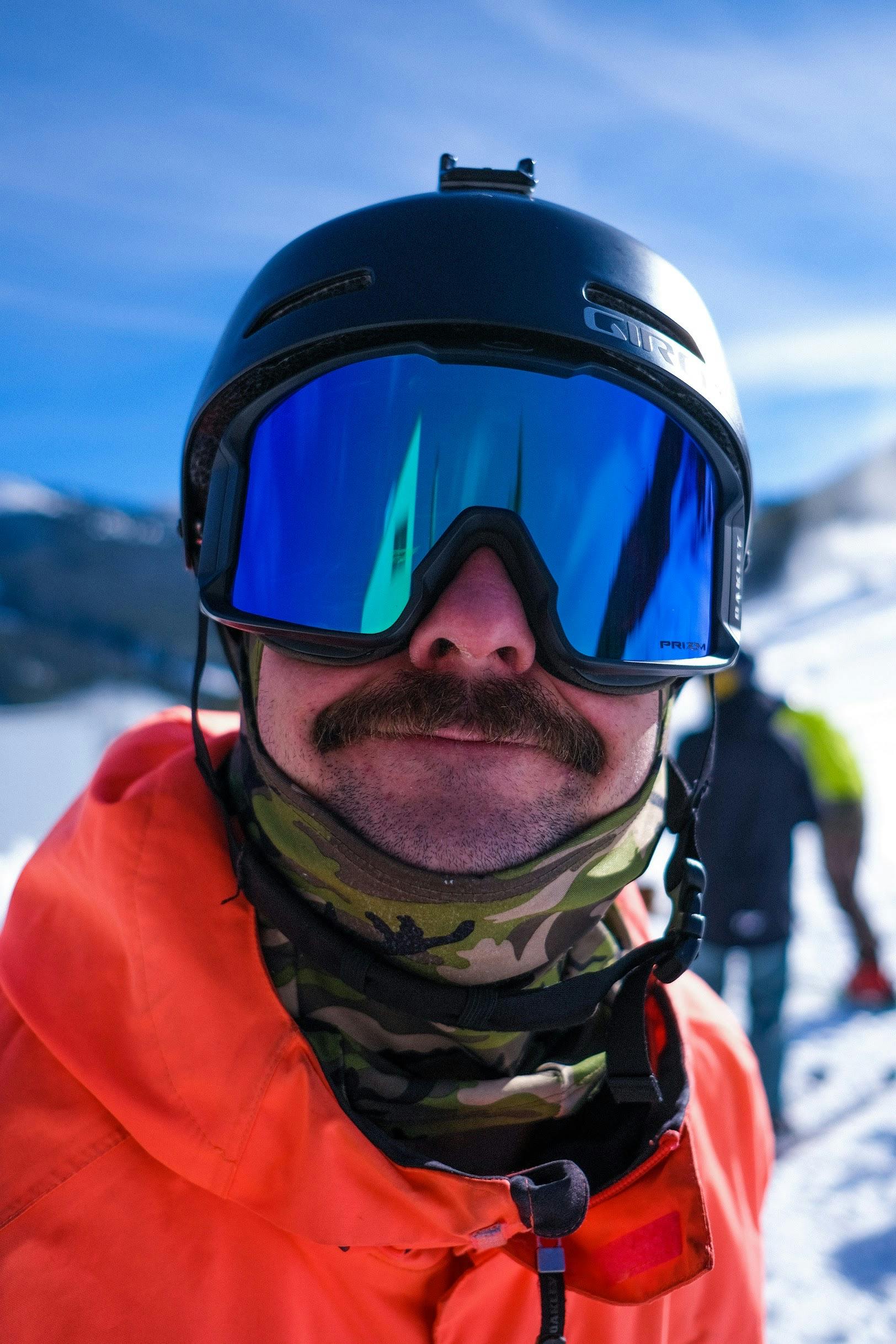 Close up of a skier wearing goggles, and the Giro Ledge helmet. 
