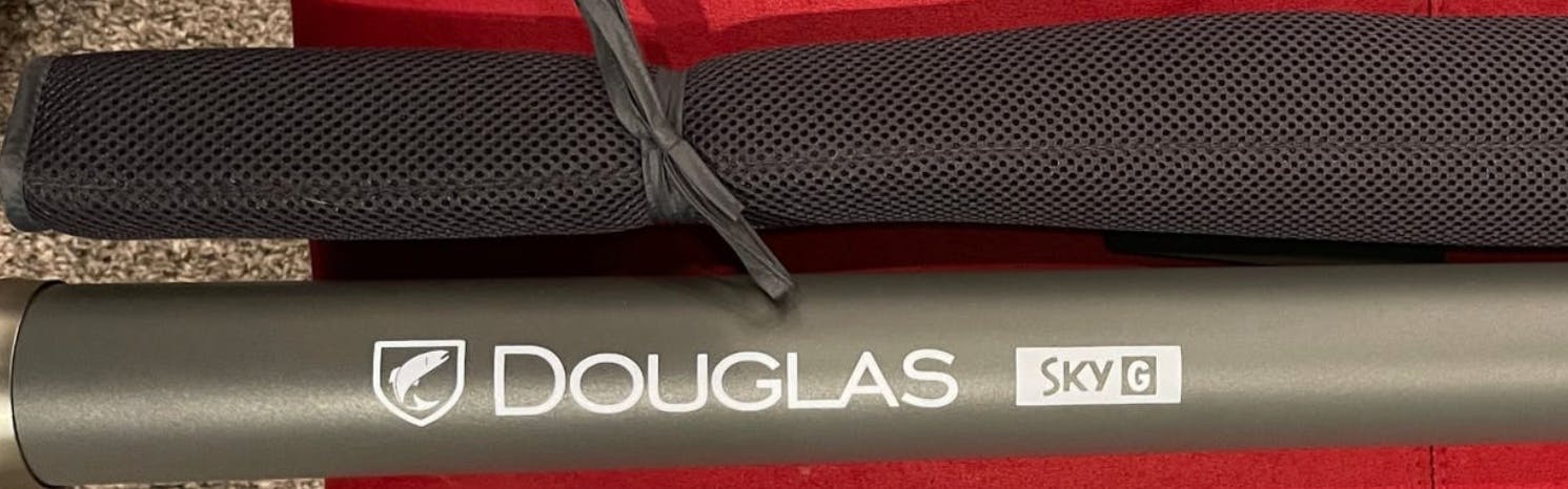 The Douglas SKY G Fly Rod in it's case laying on a table.