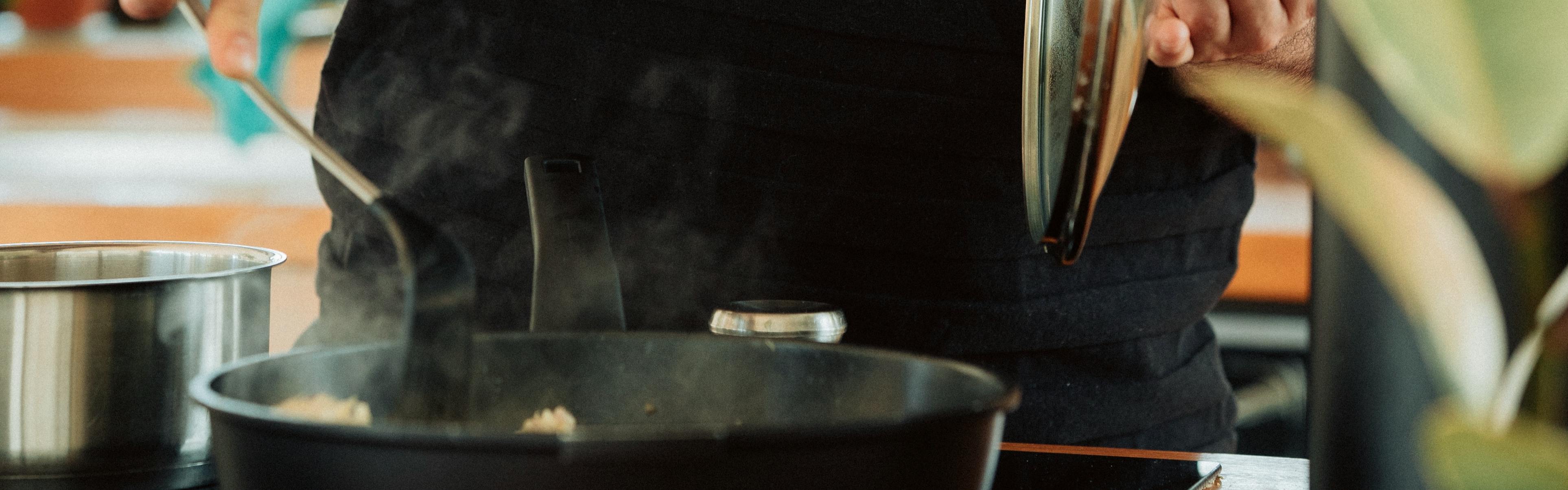 A man cooking something in a pan. 