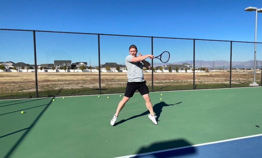 A tennis player hitting a tennis ball with the Wilson Pro Staff 97 V13.0 Racquet · Unstrung.