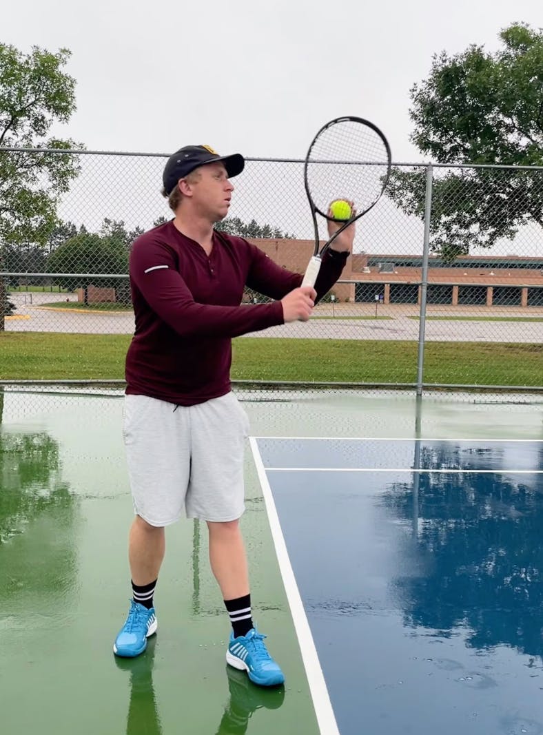 A man on a tennis court using the Head Graphene 360+ Speed Pro Racquet.