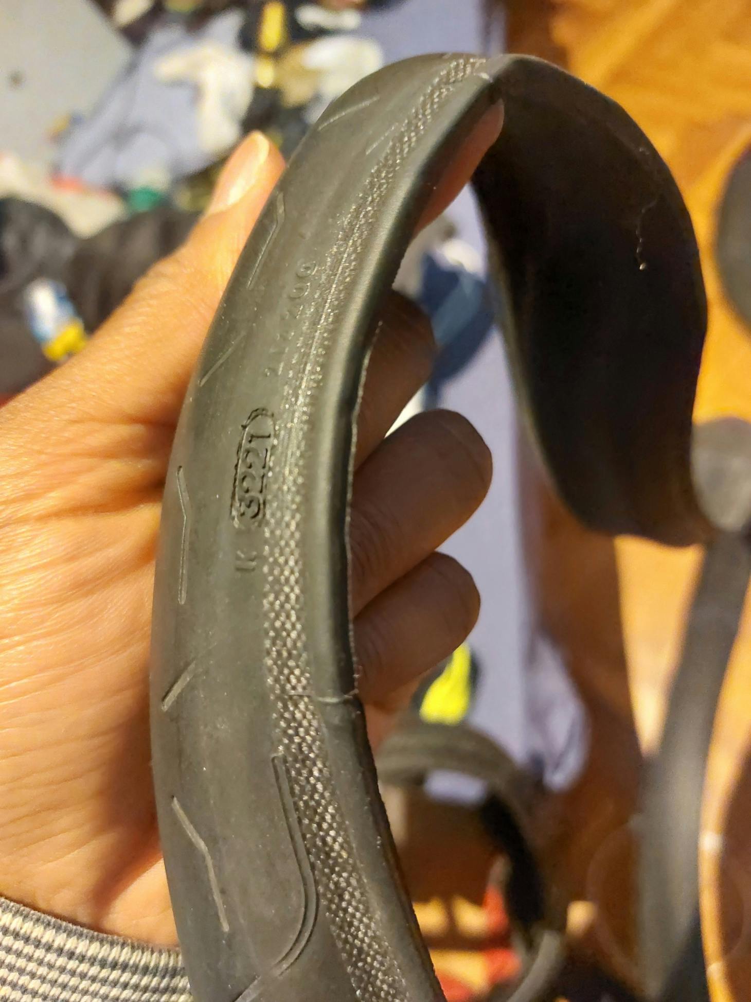A hand holding a lower end clincher tire.