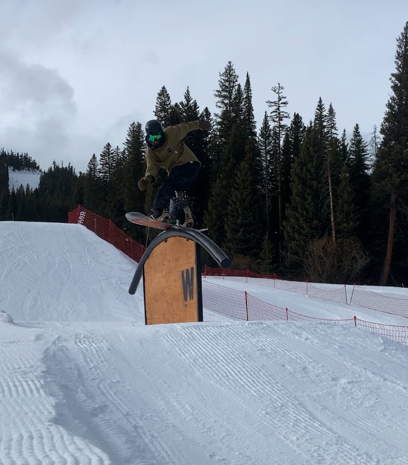 A snowboarder hitting a rail while wearing the Giro Mips helmet. 