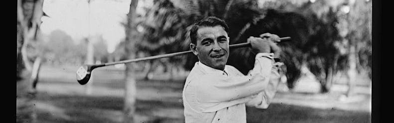 A black-and-white image of Gene Sarazen swinging back a golf club and posing for the camera.