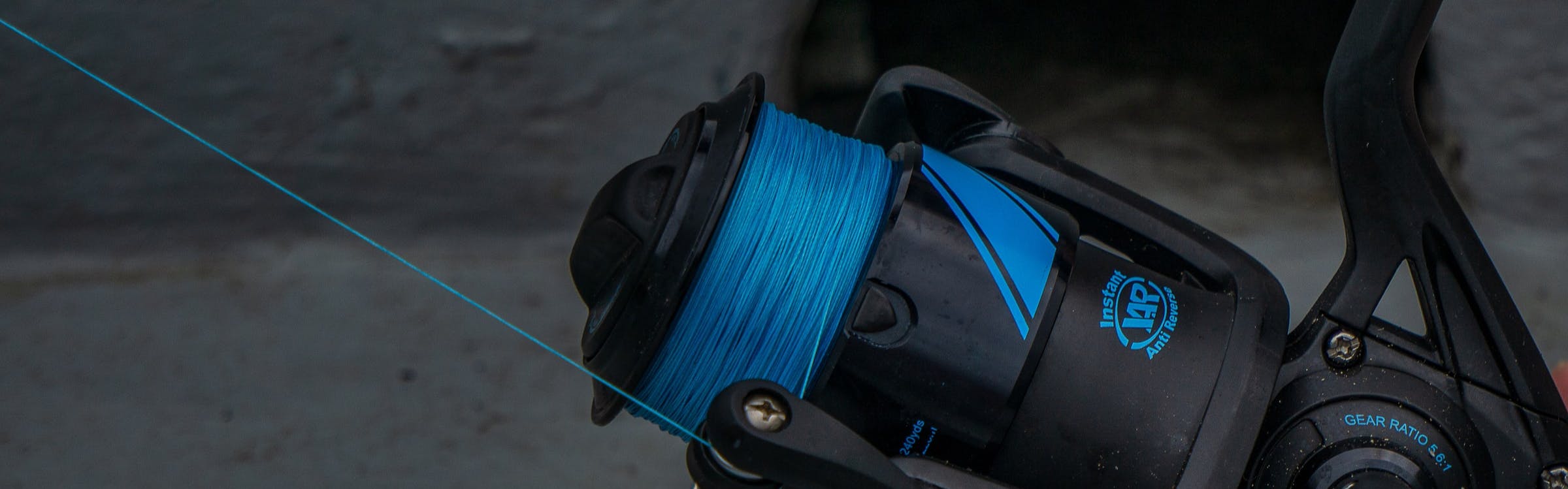 Blue fishing line being unspooled from a black reel.