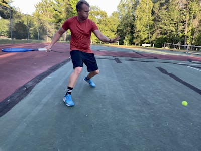 A man on a tennis court taking a swing with a Head Instinct MP 2022 Racquet.