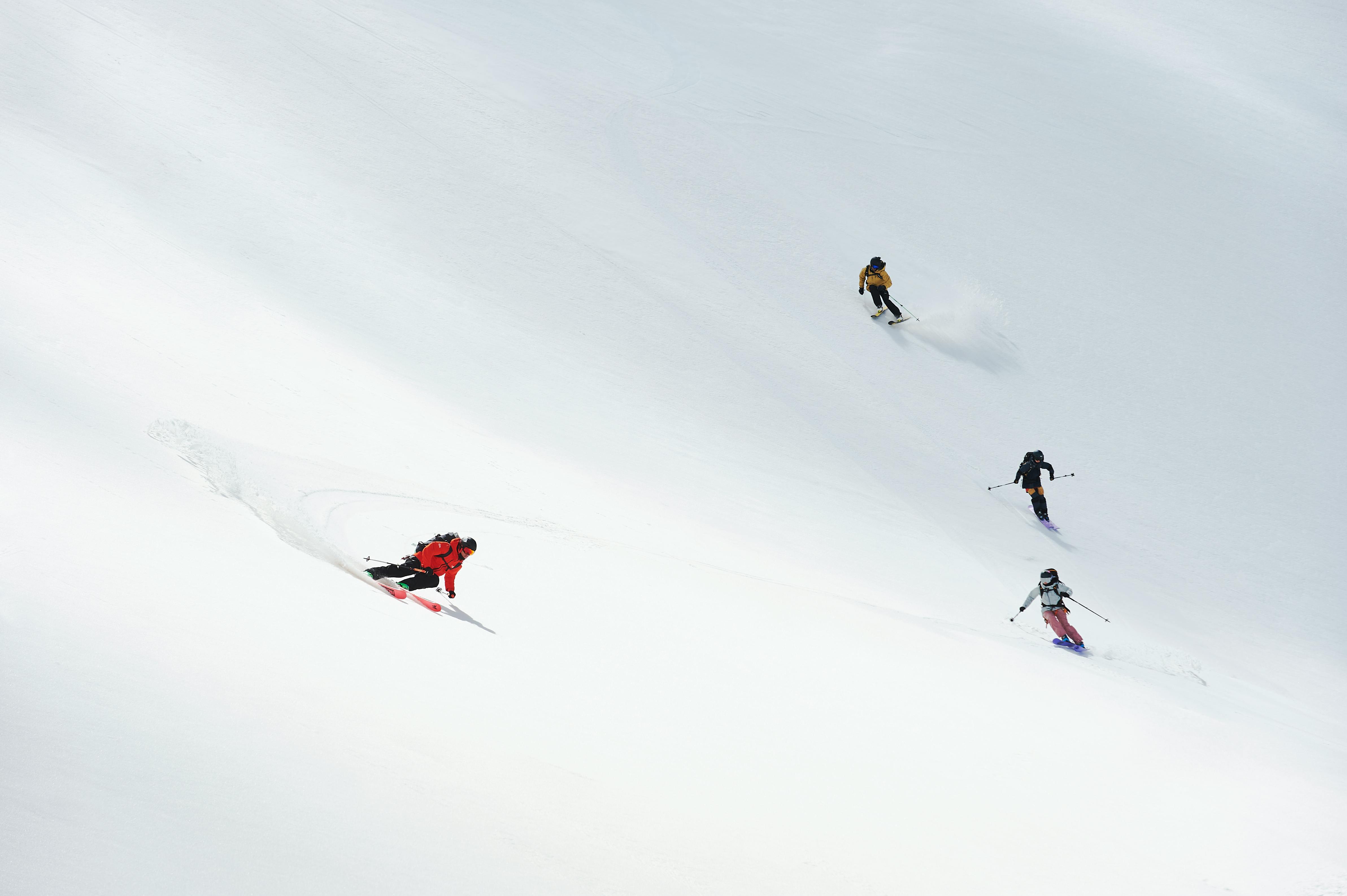 Four skiers creating fresh tracks on a pristine snowy slope