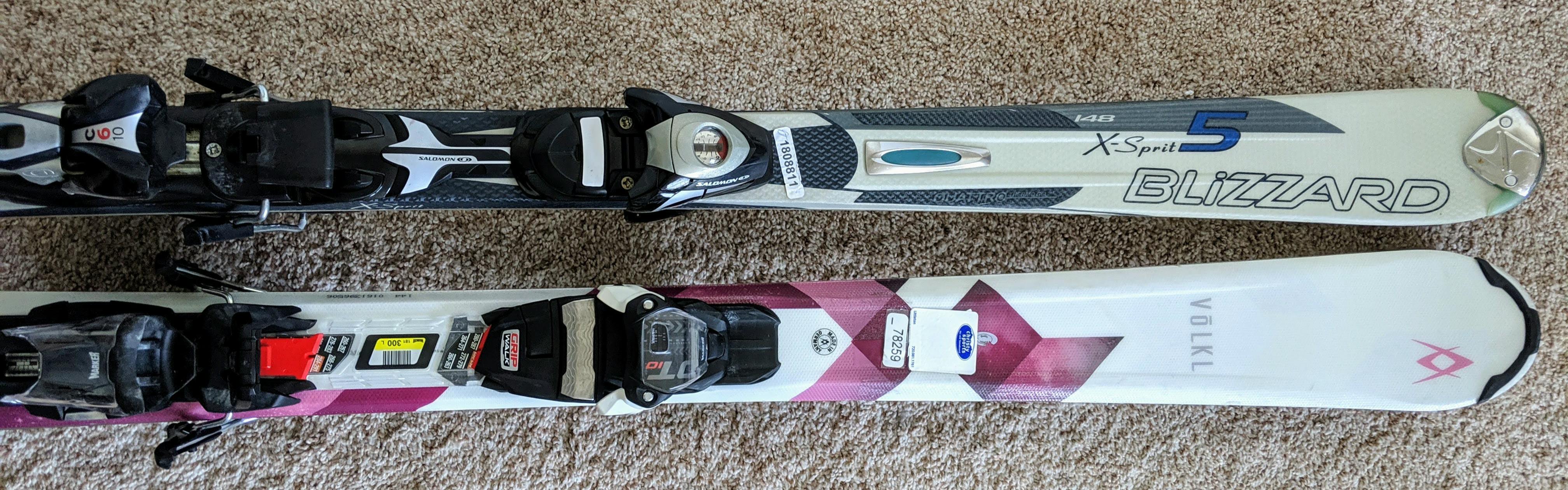 Two old beginner skis next to each other. 