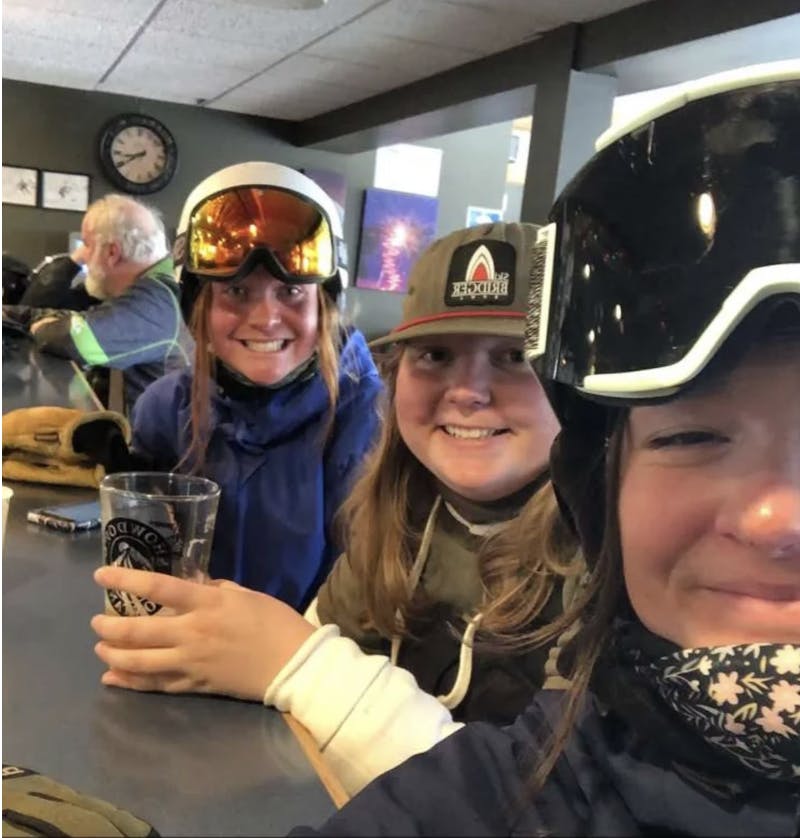 Three women sitting at a table in a ski bar. 