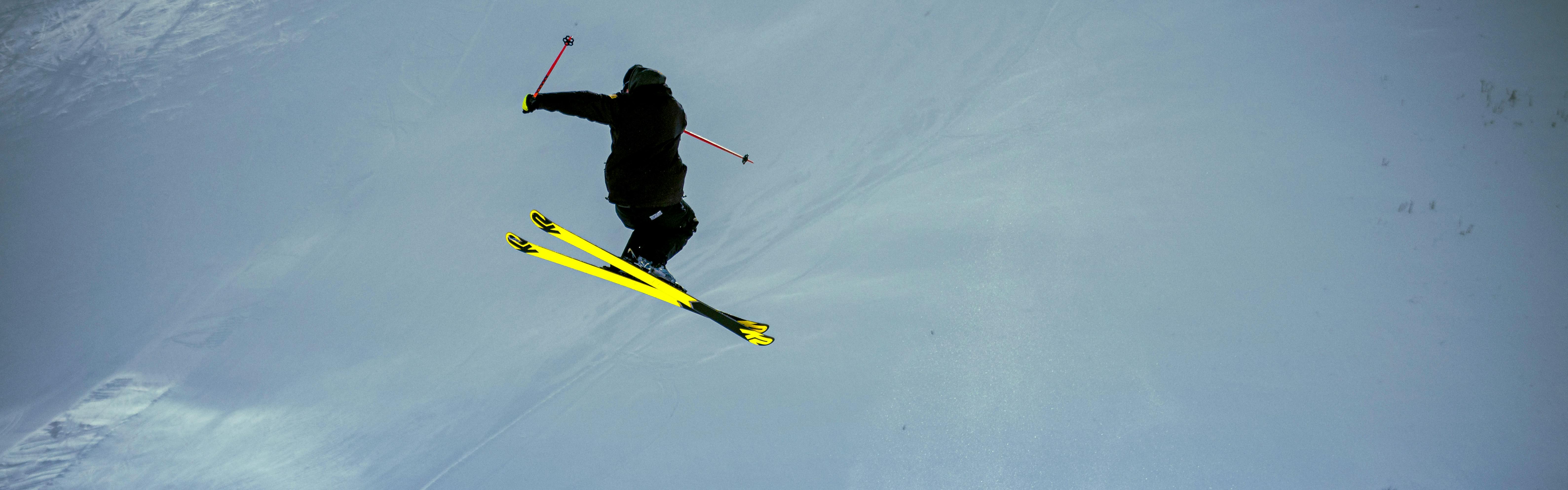 A skier on twin tip skis flying through the air in a jump