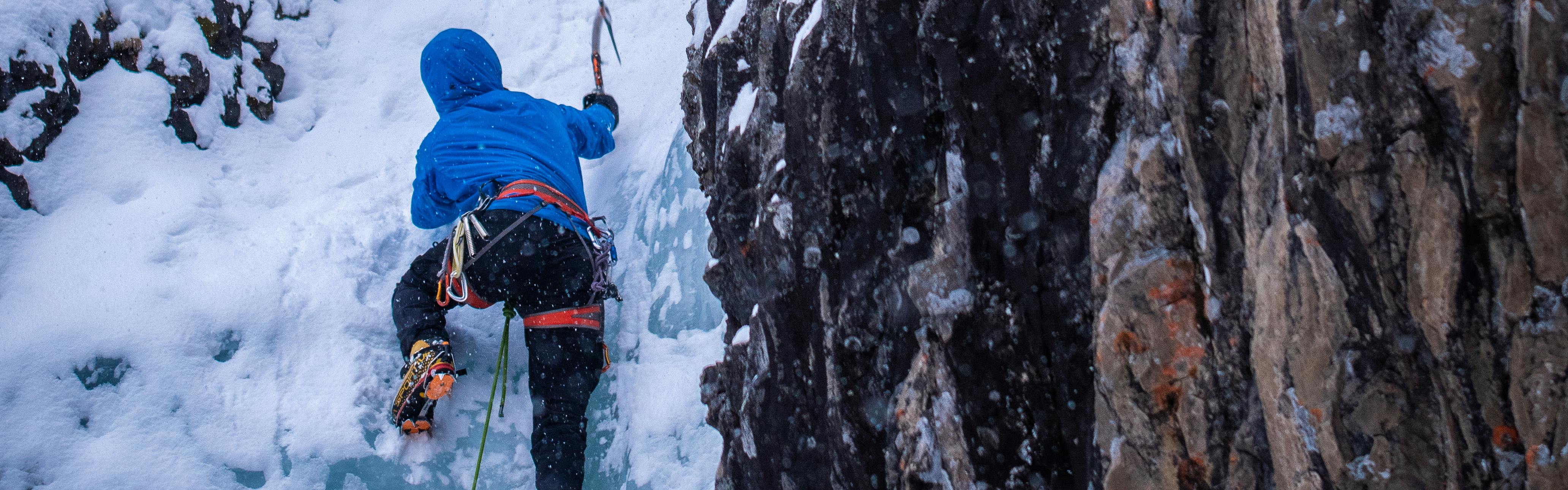 An ice climber climbing a frozen waterfall