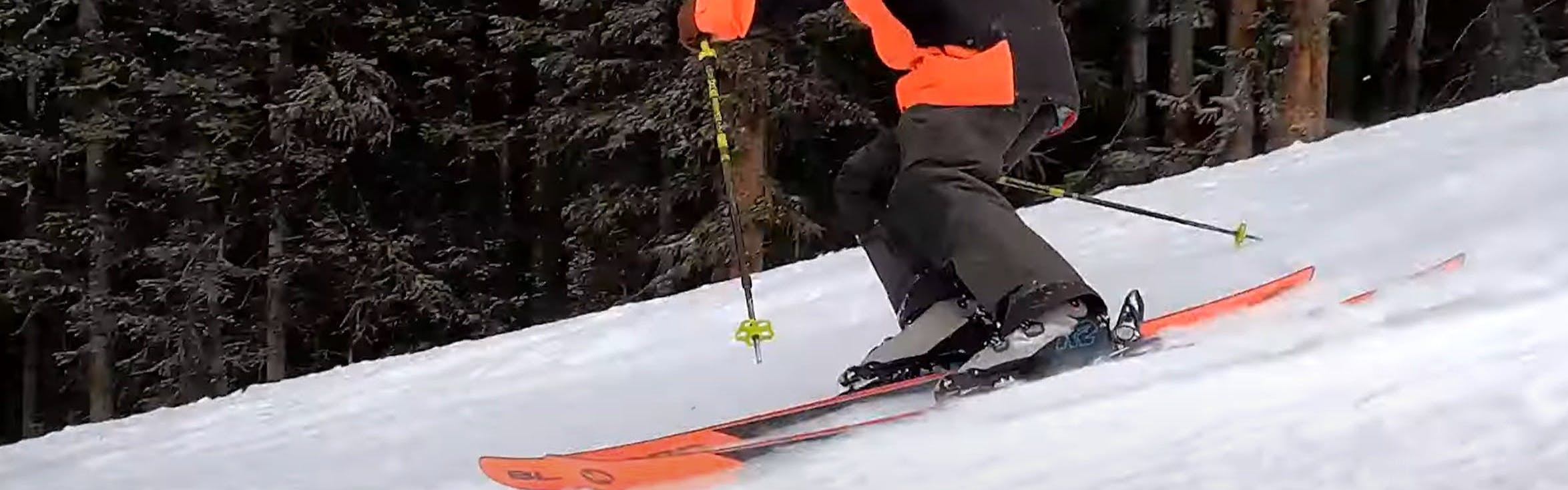 A skier turning down a mountain with the Mindbender 120 ski boots. 